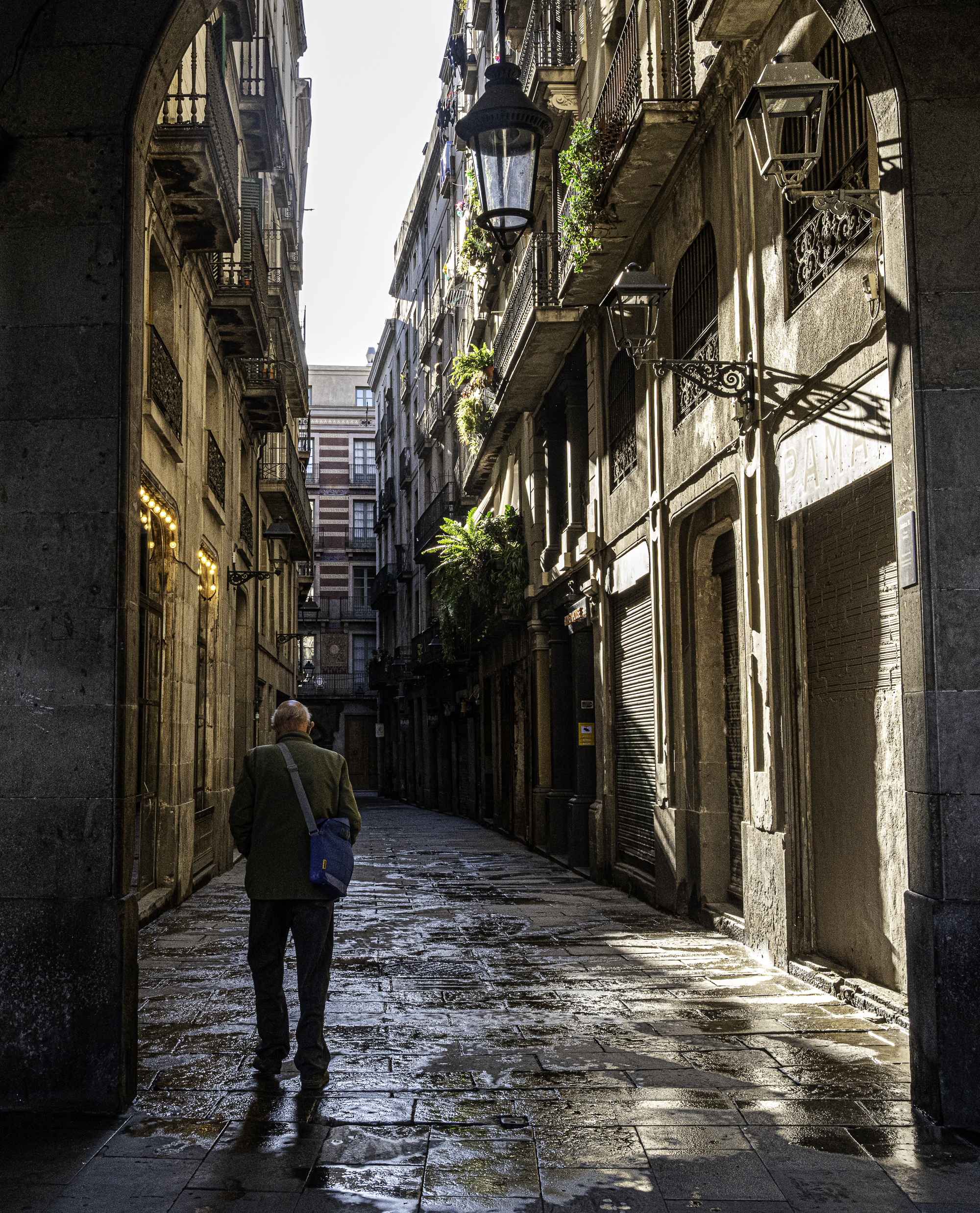 Mujer empujando la puerta de Els Quatre Gats, arco de ladrillo modernista