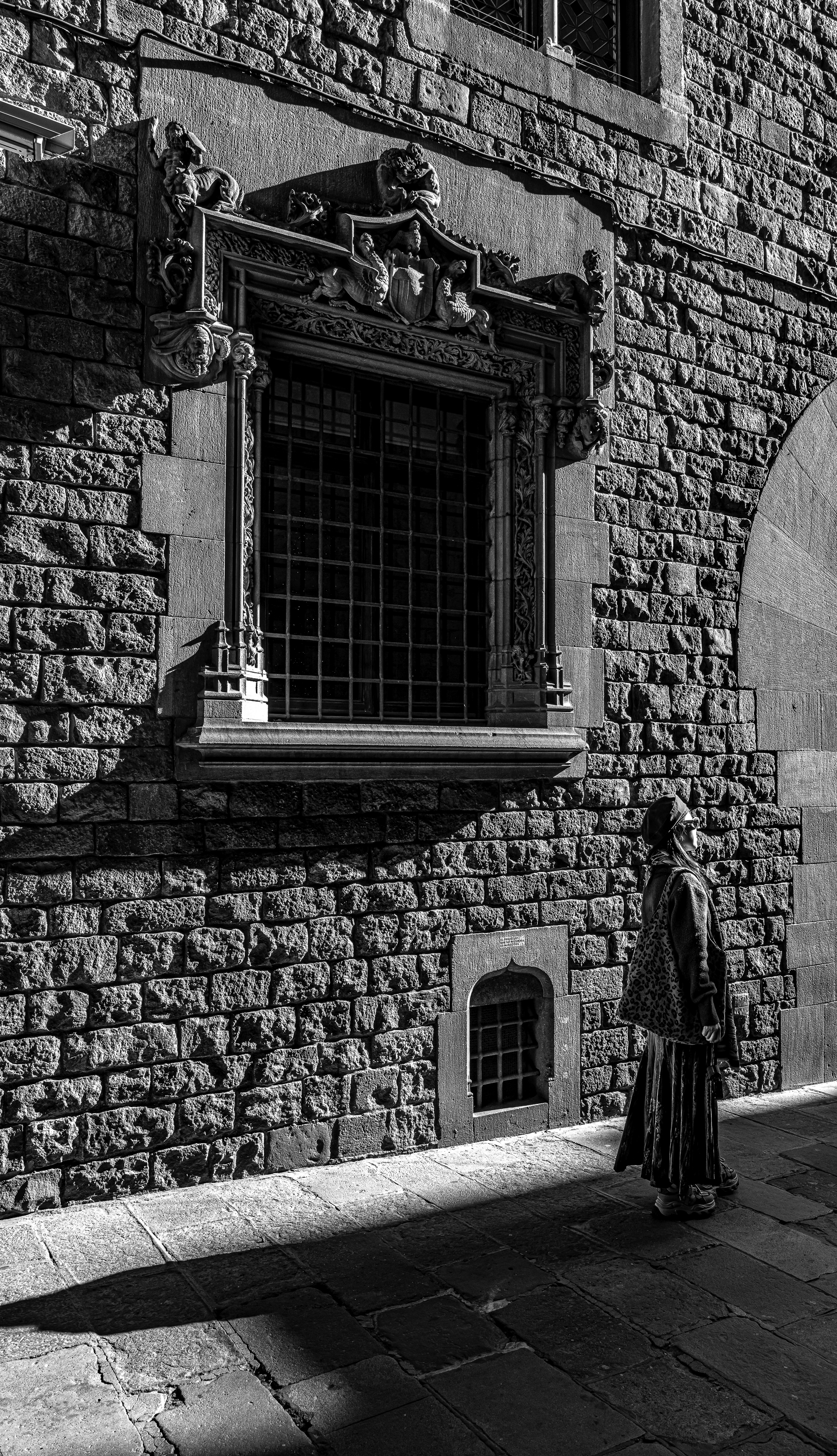 Mujer alzando la barbilla hacia la tracería del puente, quieta, posando