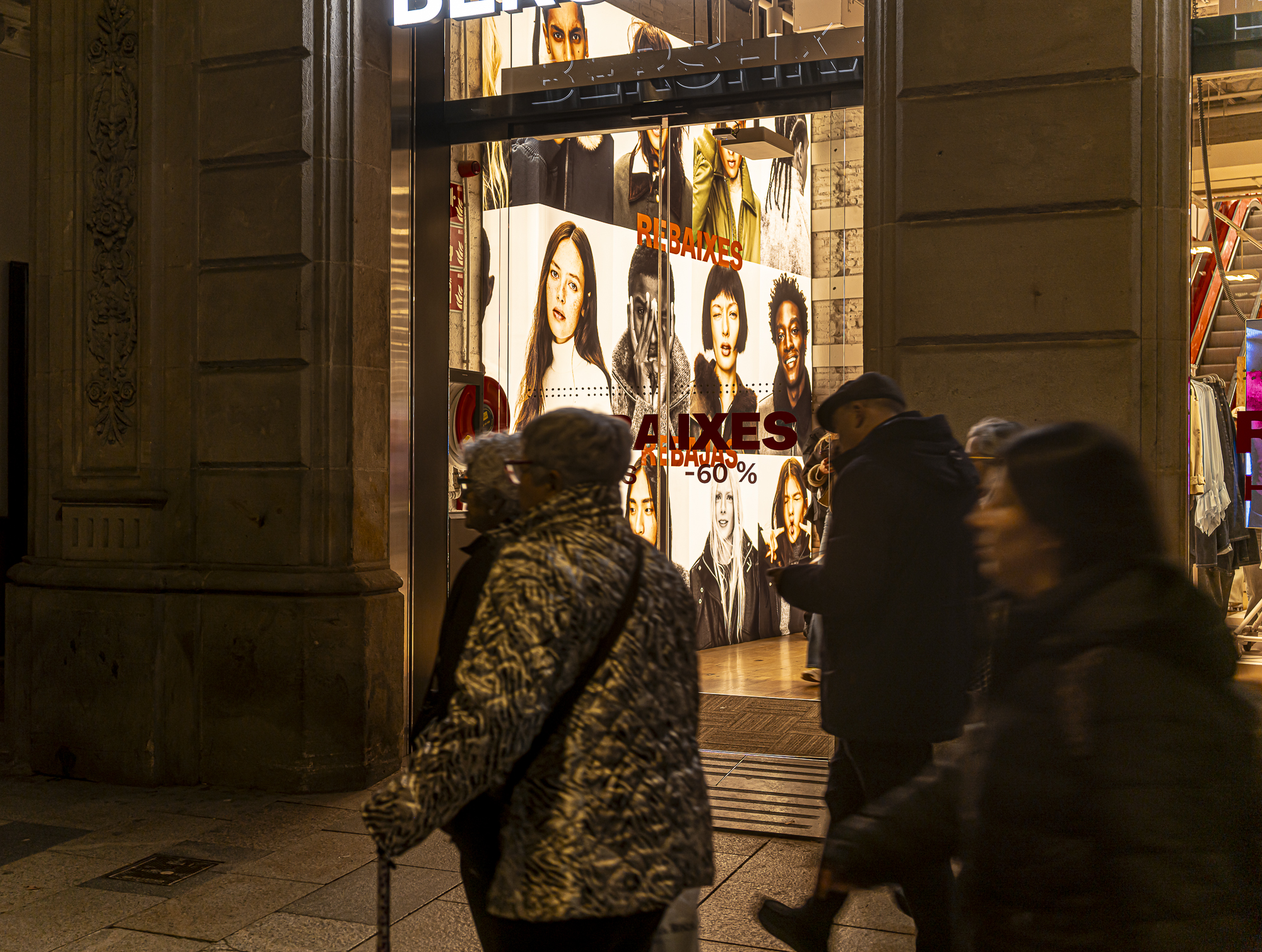 Señora con abrigo de leopardo y bastón pasando ante rostros jóvenes del escaparate