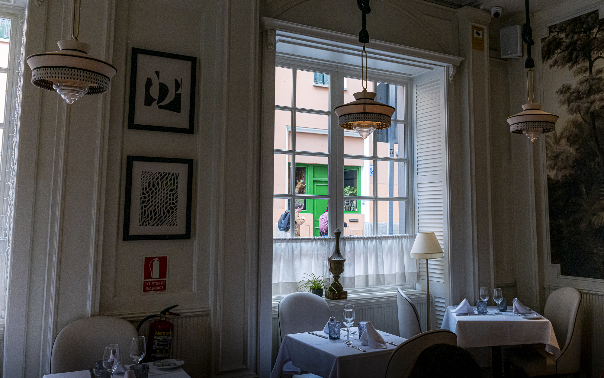 Interior de restaurante mirando a través de la ventana hacia la calle