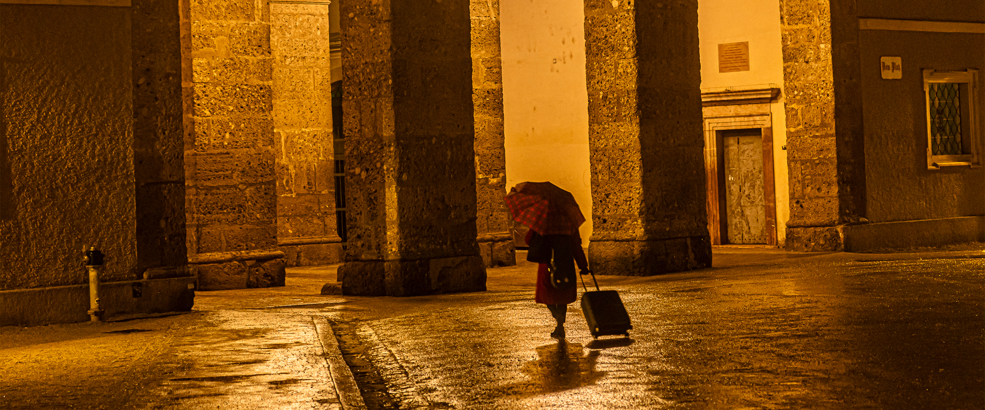 Woman with suitcase in the rain at Residenzplatz