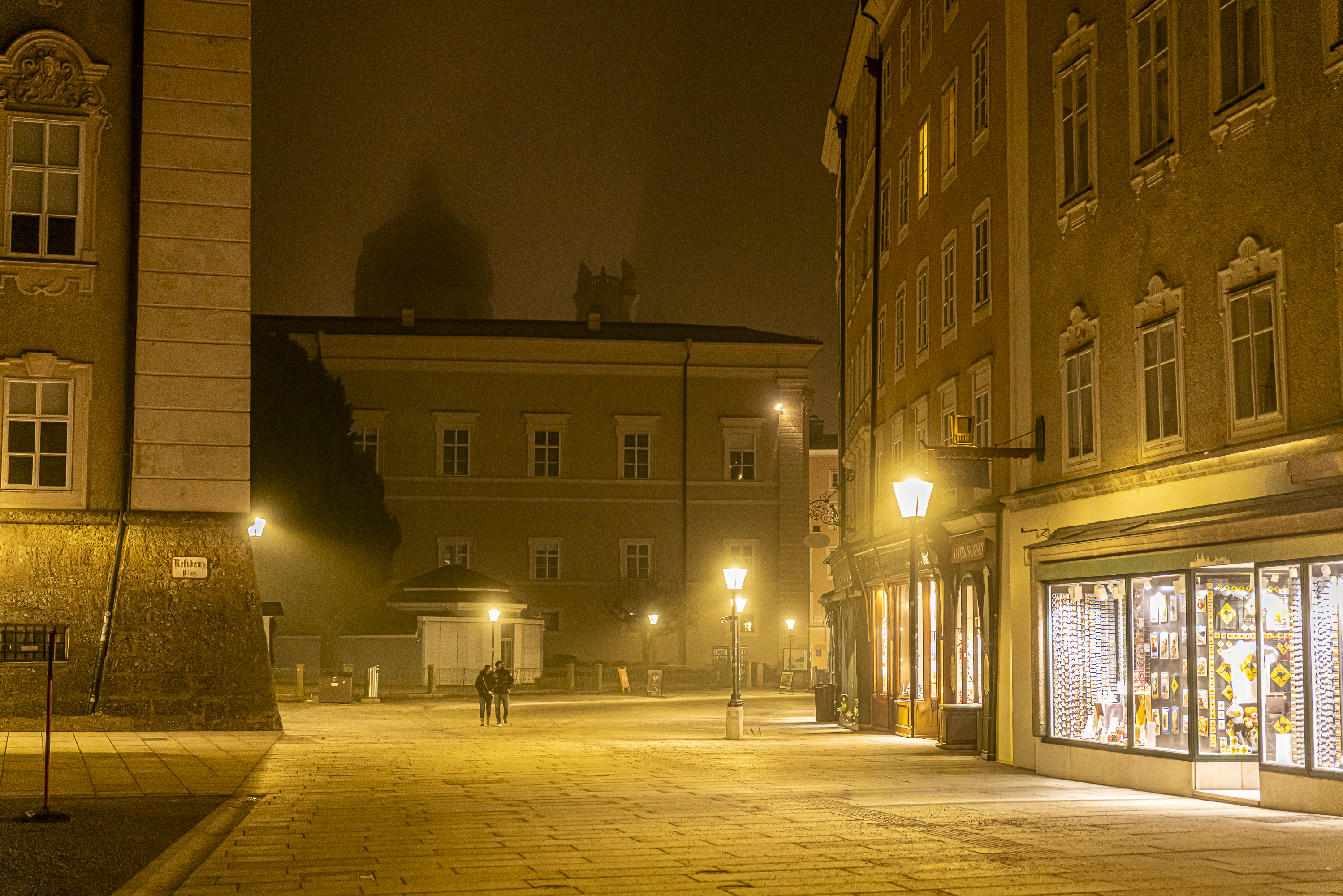 Couple walking at night beneath phantom domes in the fog