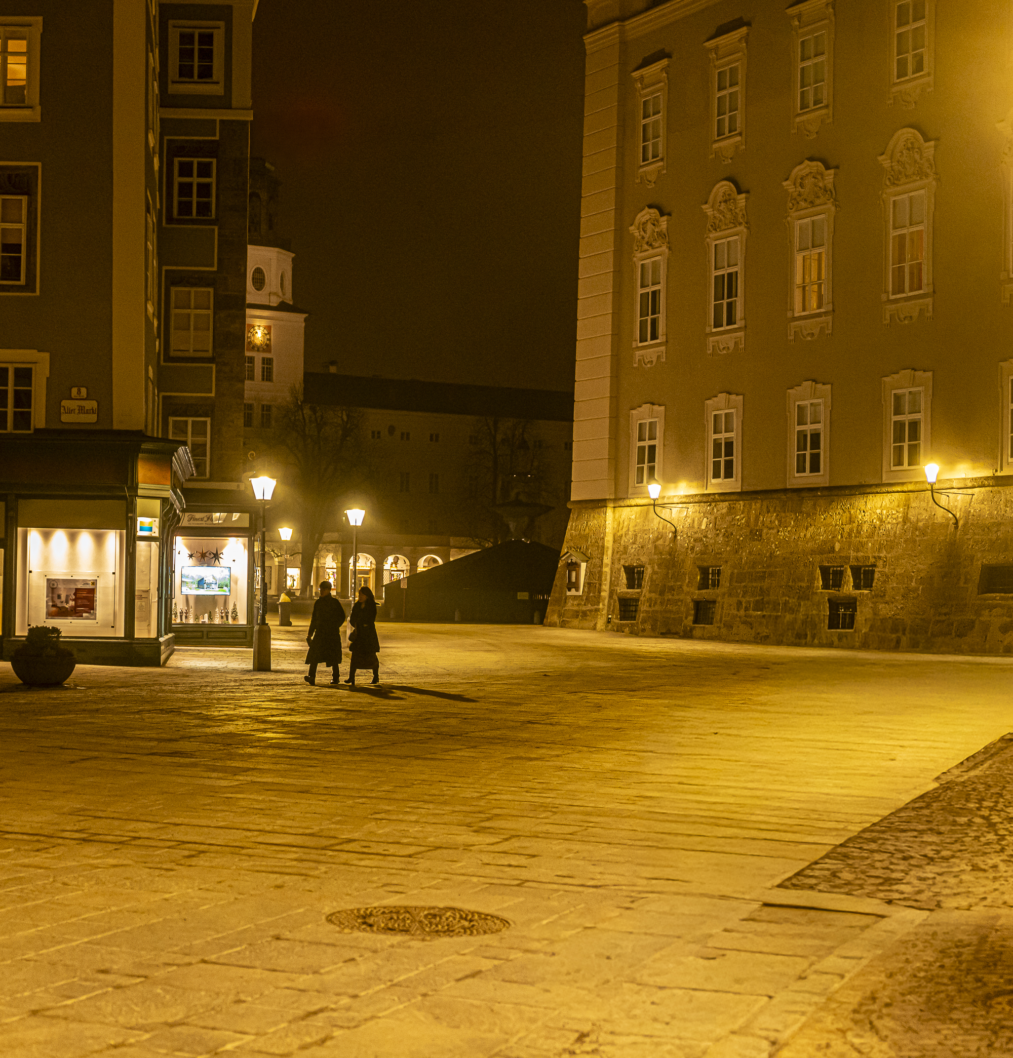 Two women walking at night through the city without looking up